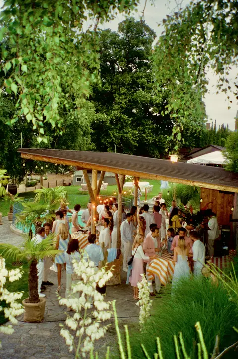 A Thell garden party — guests among the pergola, string lights and pool