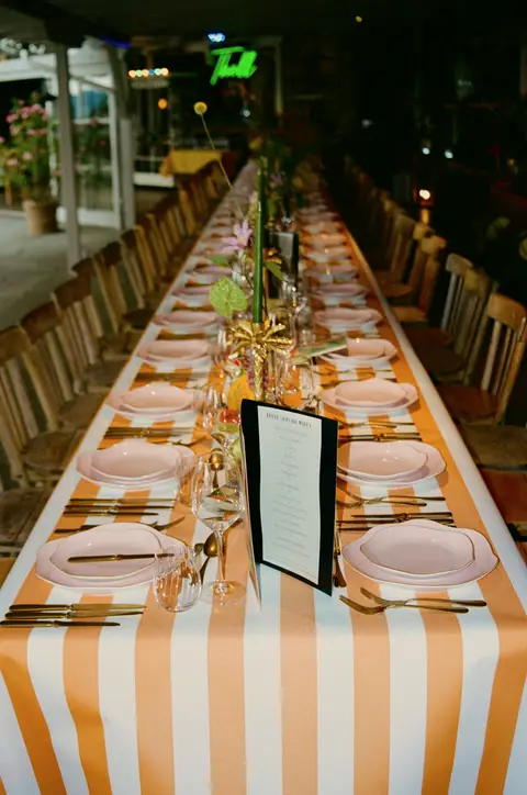Lange Catering-Tafel im Freien, festlich gedeckt mit Menükarten