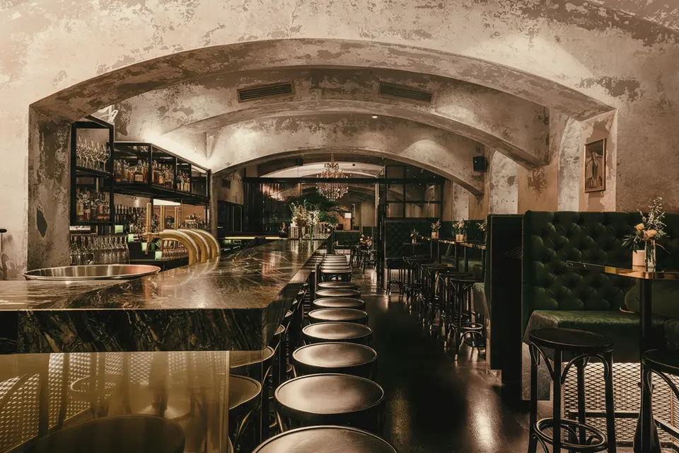 Innenraum der Thell-Bar mit Marmortresen und grünen Samtbänken